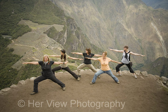 Warrior yoga pose atop Hyuana Picchu, Machu Picchu in the background below